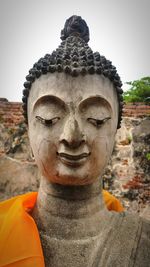 Close-up of buddha statue against building