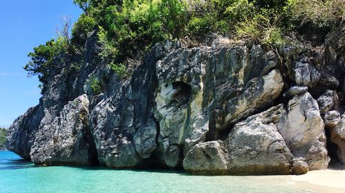 Panoramic view of rock formation in sea against sky