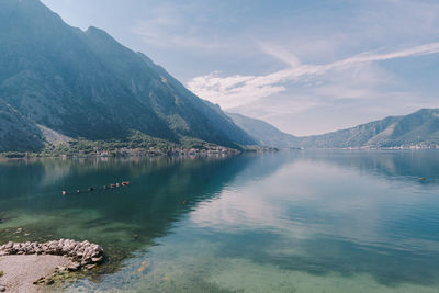 Scenic view of lake by mountains against sky