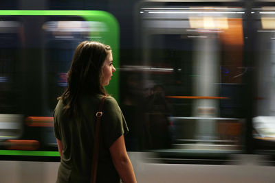Woman looking at blur train at subway station