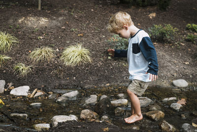 Full length of boy playing in stream