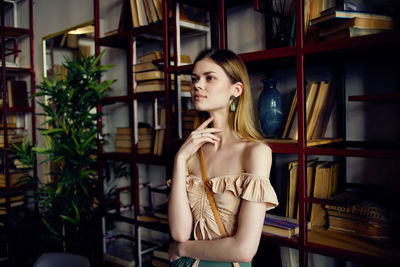 Beautiful young woman looking down while standing indoors