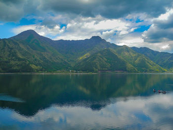 Scenic view of lake by mountains against sky