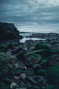 Scenic view of rocks on beach against sky