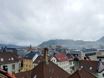 Buildings in town against cloudy sky