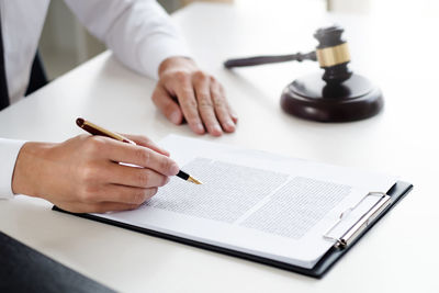 Midsection of woman reading book on table