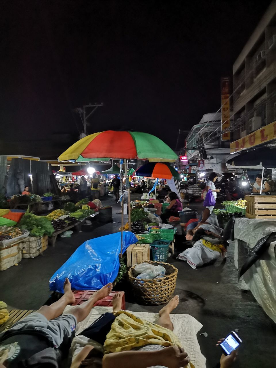 PEOPLE IN MARKET STALL AT NIGHT