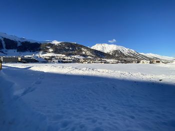 Scenic view of snowcapped mountains against blue sky