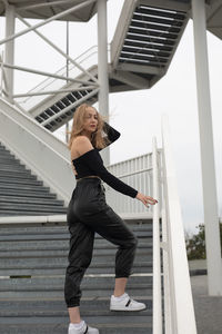 Full length of woman standing on staircase