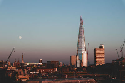 Modern buildings against clear sky during sunset