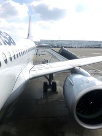 Airplane on airport runway against sky