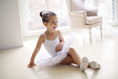 Little ballerina girl 2 years in the studio in a white tutu dress clothes