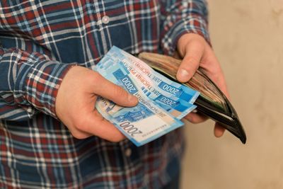 Midsection of man removing paper currencies from wallet