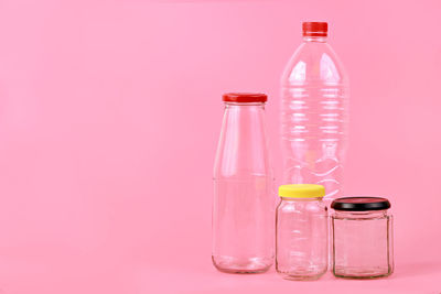Close-up of containers against pink background