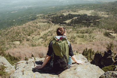 Man sitting on landscape against mountain