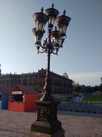 Illuminated street light against clear sky