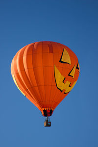 Low angle view of hot air balloon against clear blue sky