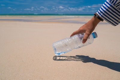 Midsection of person on sand at beach