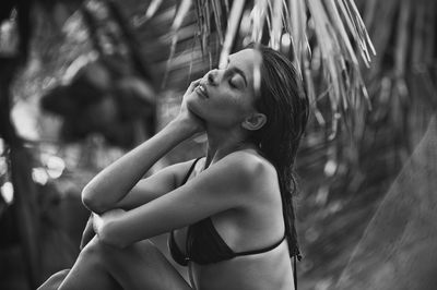 Side view of young woman sitting outdoors