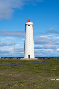 Lighthouse by sea against sky