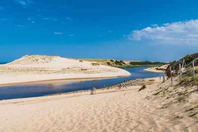 Scenic view of beach against blue sky