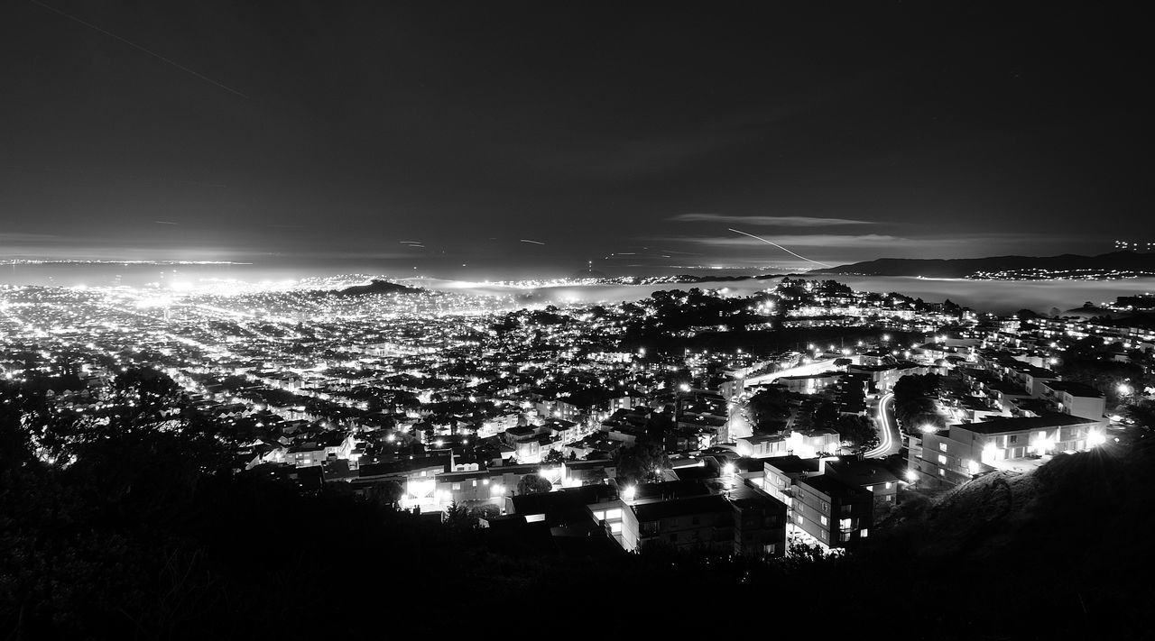 AERIAL VIEW OF ILLUMINATED CITY AGAINST SKY AT NIGHT