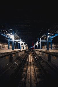 Railway tracks at railroad station at night