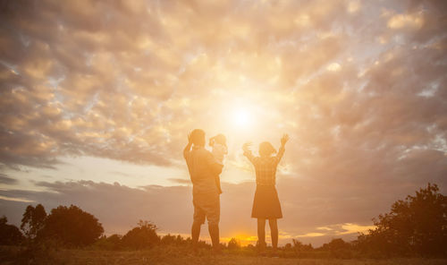 Friends standing against sky during sunset