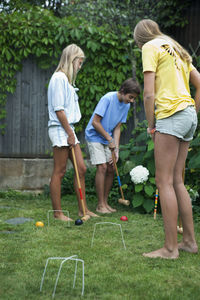 Teenagers playing croquet in garden, sweden