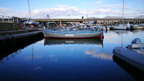 Boats moored in water against sky