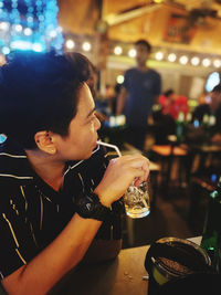 Portrait of woman drinking glass in restaurant