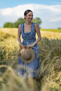 Portrait of young woman standing on field