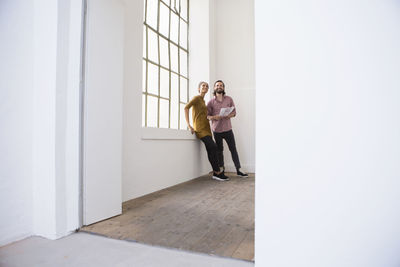 Young couple in new home looking around