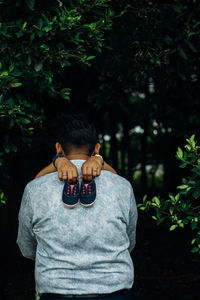 Portrait of young man standing against plants