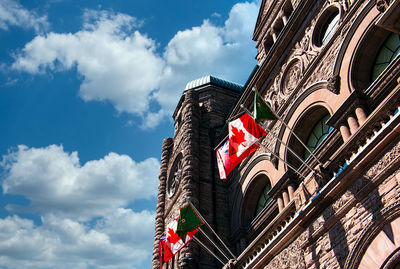 Low angle view of flag on building against sky