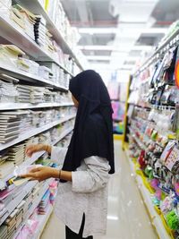 Side view of woman standing at store