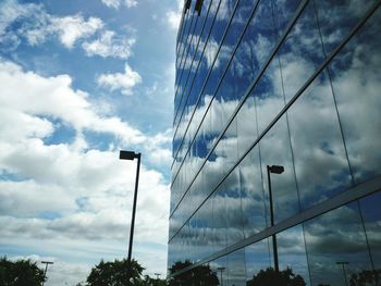 Low angle view of modern building against cloudy sky