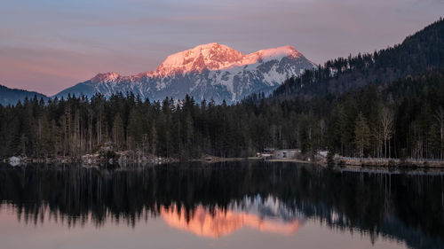 Scenic view of lake and mountains against sky at sunset