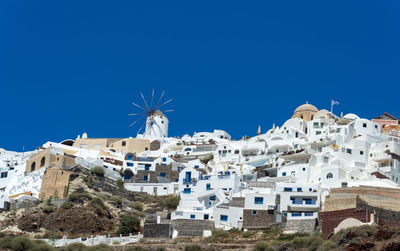 Panoramic view of oia town in santorini island with old whitewashed  traditional windmill, greece