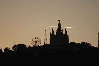 Low angle view of silhouette building against sky during sunset