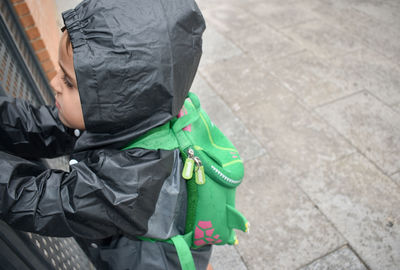 Rear view of man with umbrella on street