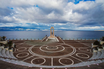 Statue by sea against sky