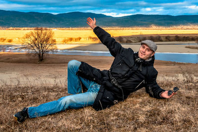 Young man with arms raised on field