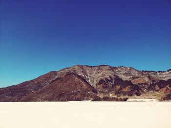 Scenic view of mountains against clear blue sky