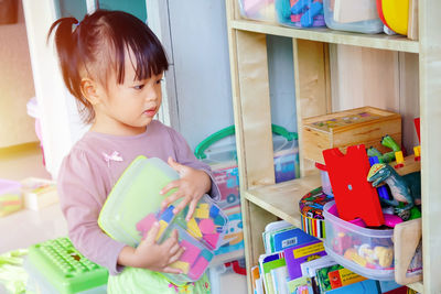 Cute girl holding toy at home