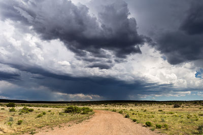 Scenic view of field against storm clouds