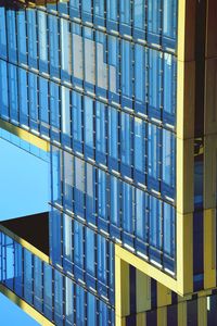 Low angle view of modern building against clear blue sky