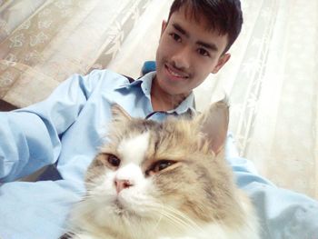 Portrait of smiling young man sitting on sofa at home