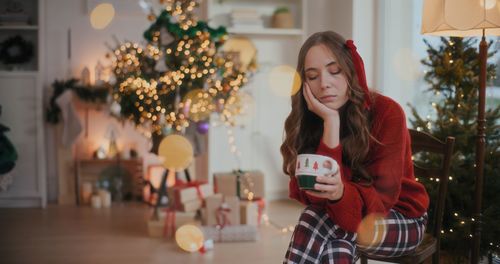 Portrait of young woman holding christmas tree