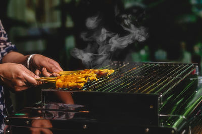 Man preparing food on barbecue grill